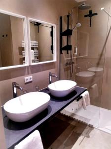 德累斯顿德累斯顿诺瓦利斯酒店的浴室的2个水槽,位于一个柜台上,设有淋浴