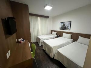 贝洛奥里藏特Nobile Hotel Belo Horizonte的酒店客房设有两张床和电视。