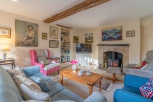 赛伦塞斯特Woodmancote Manor Cottage的带沙发和壁炉的客厅