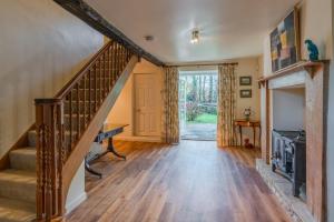 赛伦塞斯特Woodmancote Manor Cottage的一间带楼梯和壁炉的客厅