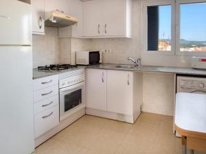 帕拉莫斯Piso les Pites的厨房配有白色橱柜和炉灶烤箱。