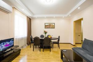 第比利斯Rustaveli Three Bedroom Apartment with Amazing views的客厅配有桌椅和沙发