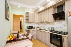 第比利斯Rustaveli Three Bedroom Apartment with Amazing views的厨房配有木制橱柜和水果桌。