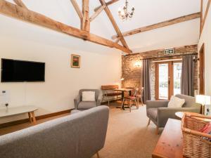 伍斯特Clover Patch Cottage的客厅配有沙发、椅子和电视