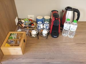 卡尔季察Olive Deluxe Room的一张桌子、一个咖啡壶和瓶装水