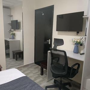 内罗毕Sharz place的一间卧室配有一张桌子、一把椅子和一台电脑