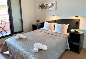 阿维尼翁圣玛尔特公寓式酒店的一间卧室配有一张大床和毛巾
