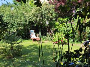 勒芒Chambres d'hôtes de charme sur LE MANS的花园,花园内摆放着椅子,位于草地上