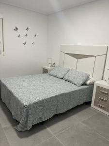 埃尔切Confortable adosado en Elche的卧室配有一张床上的蝴蝶壁床。