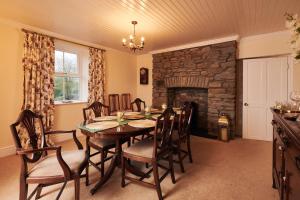 卡马森Castell Y Waun- Beautiful and spacious country farmhouse with luxury Hot Tub & Grounds的一间带桌子和石头壁炉的用餐室