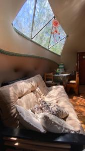 卡皮亚德尔德尔蒙特Domo Cielos del Uritorco的一间卧室设有一张床和一个大窗户
