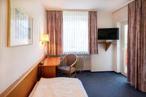 希尔德斯海姆斯坦伯格酒店的酒店客房配有书桌、床和电视。