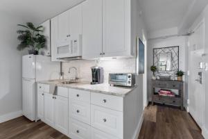 代托纳海滩oceanside inn的厨房配有白色橱柜、水槽和微波炉