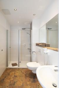 希尔德斯海姆斯坦伯格酒店的带淋浴、两个盥洗盆和卫生间的浴室