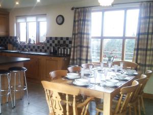 MochdreCwm Corn Barn - Hw7662的一间带木桌和椅子的厨房以及一间用餐室