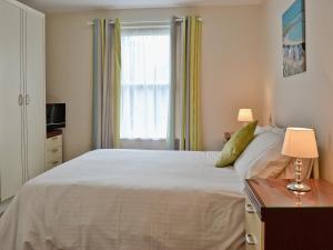 Stokeinteignhead蓝钟乡村别墅的卧室配有一张大白色床和窗户
