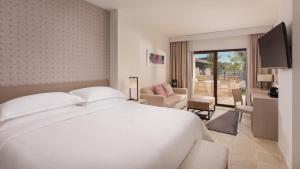 弗安特阿拉莫Ona Hacienda del Álamo Golf Resort的一间带白色床的卧室和一间客厅
