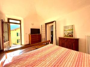 伦诺BORGO CAMILLO的一间卧室设有一张床、一台电视和一个窗口。