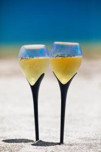 佩德拉斯港Bahay Tatu的两杯葡萄酒坐在沙滩上