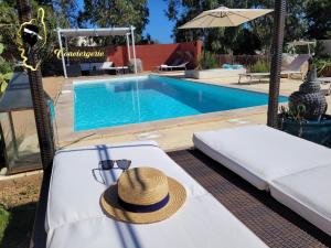 LecciCasa Salya 8 pers Piscine privée San Cipriano的坐在游泳池畔床边的帽子