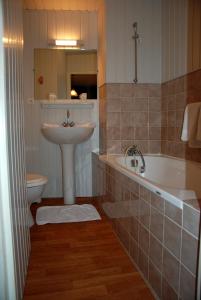 蓬托尔松法兰西酒店的一间带水槽、浴缸和卫生间的浴室