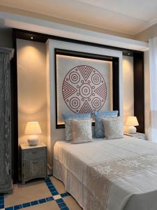 皮诺港Villa Aquamarina Pintadera Rossa的卧室配有一张大床,墙上挂着一幅画