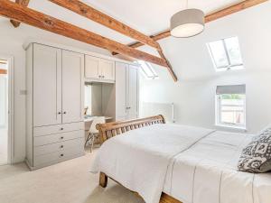 BraunstonThe Granary的白色卧室配有床和书桌