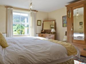 MukerHarriets Cottage的一间卧室设有一张大床和一个窗户。