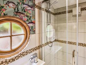 韦尔斯Walnut Lodge的带淋浴和盥洗盆的浴室以及窗户。