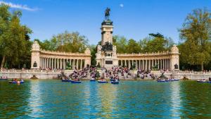 马德里HABITACIÓN en el centro de Madrid的一群人坐在雕像前的水中独木舟