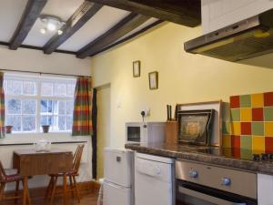 AlrewasSwiss Cottage - E5375的厨房配有台面和桌子