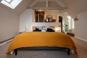 库唐斯La Villégiature的一间卧室配有一张带黄色毯子的大床