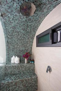 别霍港Saranda Boutique Hotel的一间带淋浴的浴室和瓷砖墙