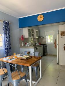 威廉斯塔德Lilu Apartments Curaçao的厨房配有桌椅和天花板上的时钟