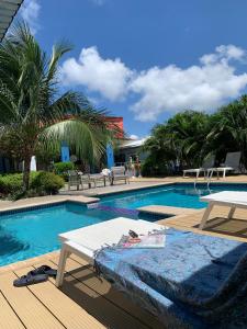 威廉斯塔德Lilu Apartments Curaçao的一个带野餐桌和桌子的游泳池