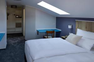 塞海姆-尤根海姆Hotel Brasserie Chaussee的卧室配有白色的床和蓝色的墙壁