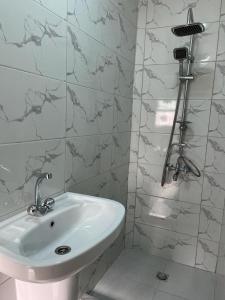 瓦迪穆萨Sultan Home的浴室铺有大理石瓷砖,配有白色水槽。