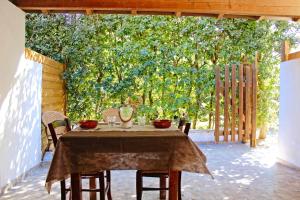 托里德欧索Villaggio Camping Sentinella的庭院里种着大树,配有桌椅