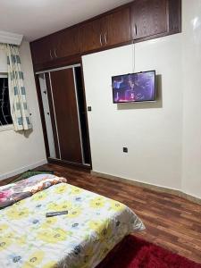 卡萨布兰卡Résidence Faouazi的一间卧室设有两张床,墙上配有电视。