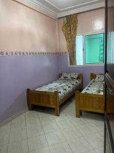 卡萨布兰卡Résidence Faouazi的一间卧室配有两张床和镜子