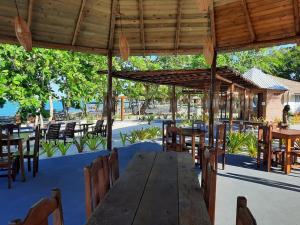 塞古罗港Resort Ondas Praia apart的户外餐厅设有木桌和椅子