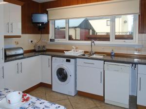 EmboOyster Catcher的厨房配有洗衣机和水槽