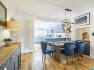 Newton FerrersThe Wicket的厨房配有餐桌和蓝色椅子