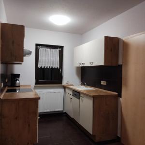 LebusAm Wiesengrund的一间小厨房,配有白色的橱柜和窗户