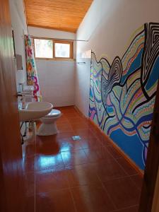 伊瓜苏港Cataratas Jazz Hostel的浴室设有两个水槽,墙上挂有绘画作品