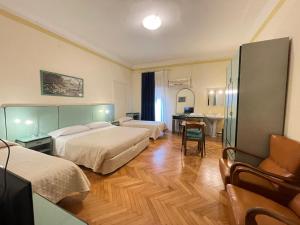 博洛尼亚Hotel Panorama Bologna Centro的酒店客房配有两张床和一张书桌
