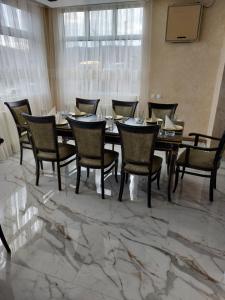 KuršumlijaJOKSIM Rooms&Restaurant的一间位于大理石地板的带桌椅的用餐室