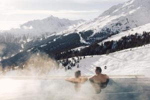 索尔登斯科恩奥西赫特酒店的两人在雪地的热水浴缸中
