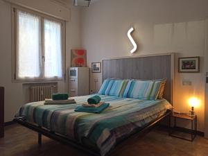 博洛尼亚Casa Alderotti的一间卧室配有一张大床和毛巾