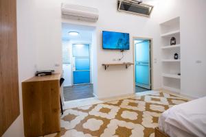 Ein Kinyaצימר סבא רבא - Saba Raba B&B的一间卧室配有一张床、一张书桌和一台电视。
